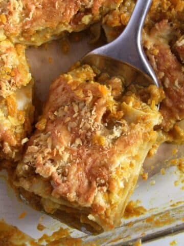 slice of chicken pumpkin lasagna with coconut sauce lifted from a pan.
