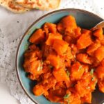 vegan afghan pumpkin recipe braised with spices in a blue bowl