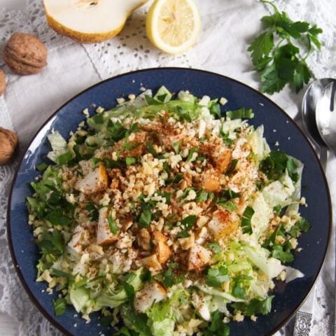 salad leaves, celeriac, pears and walnuts on a blue plate