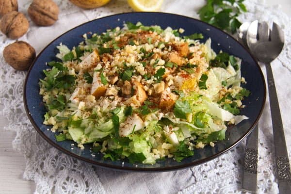 large plate full of salad leaves and chopped walnuts