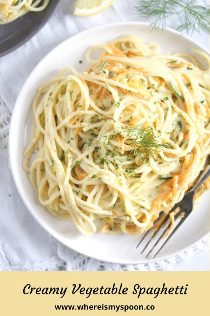 pasta dish with carrots and zucchini on a white plate