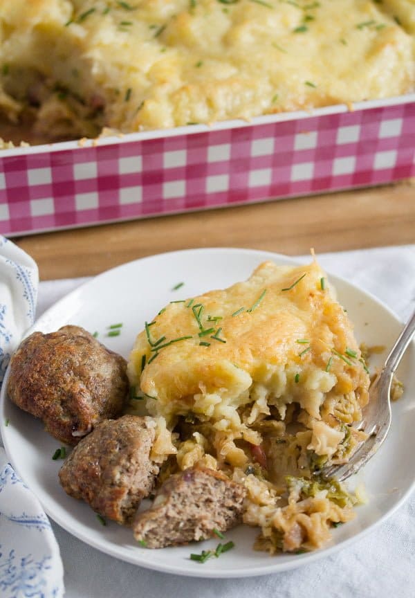 savoy cabbage with potatoes and meatballs on a white plate