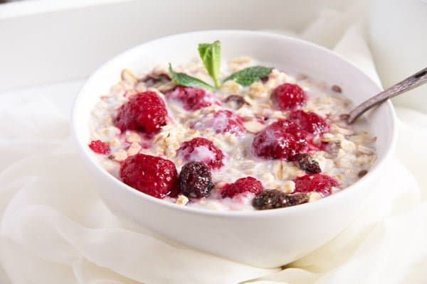 bowl of muesli with milk and raspberries