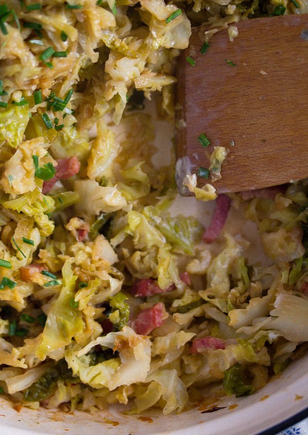 stirring sauteed savoy cabbage and bacon in a skillet