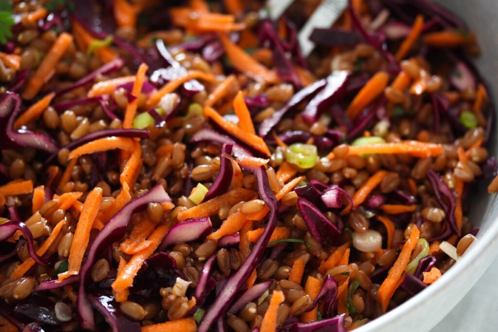 cooked spelt, red cabbage and carrots in a bowl