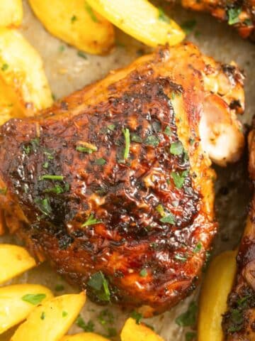 crispy chicken thighs with potatoes close up.