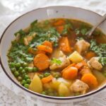 bowl of chicken and potato soup sprinkled with parsley