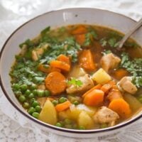 bowl of chicken and potato soup sprinkled with parsley