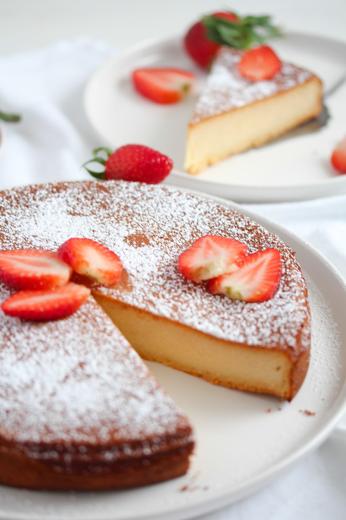 marzipan cake decorated with icing sugar and strawberries.