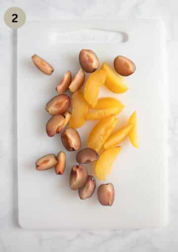 sliced yellow and red plums on a cutting board.