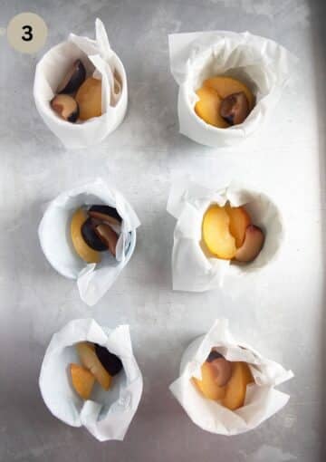 placing plum slices into ramekin dishes to make clafoutis.