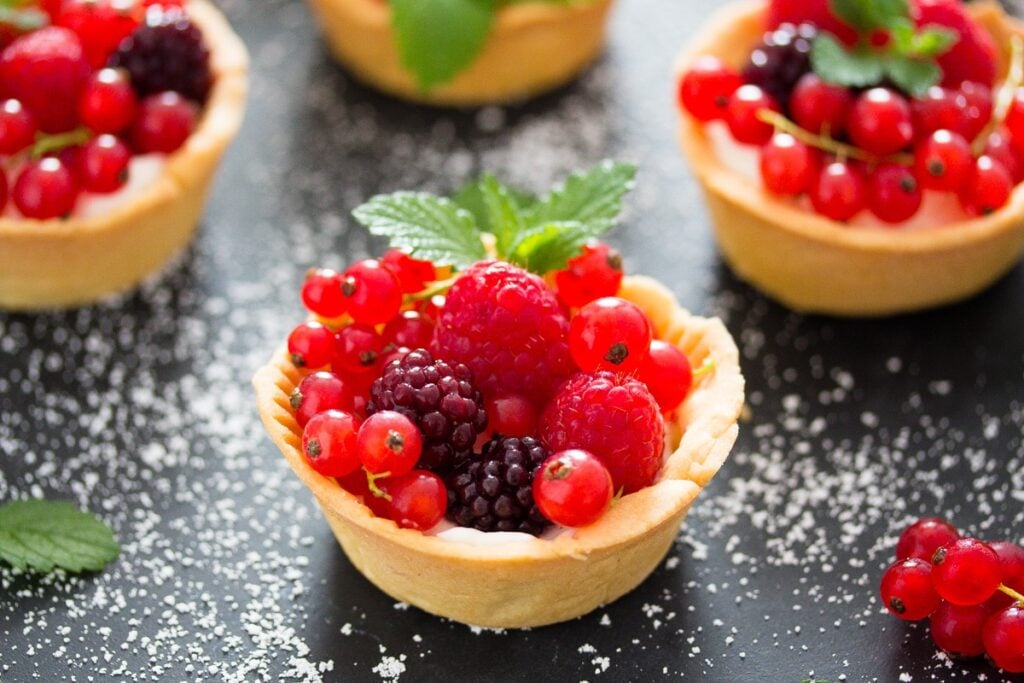 mini berry tarts on a black table