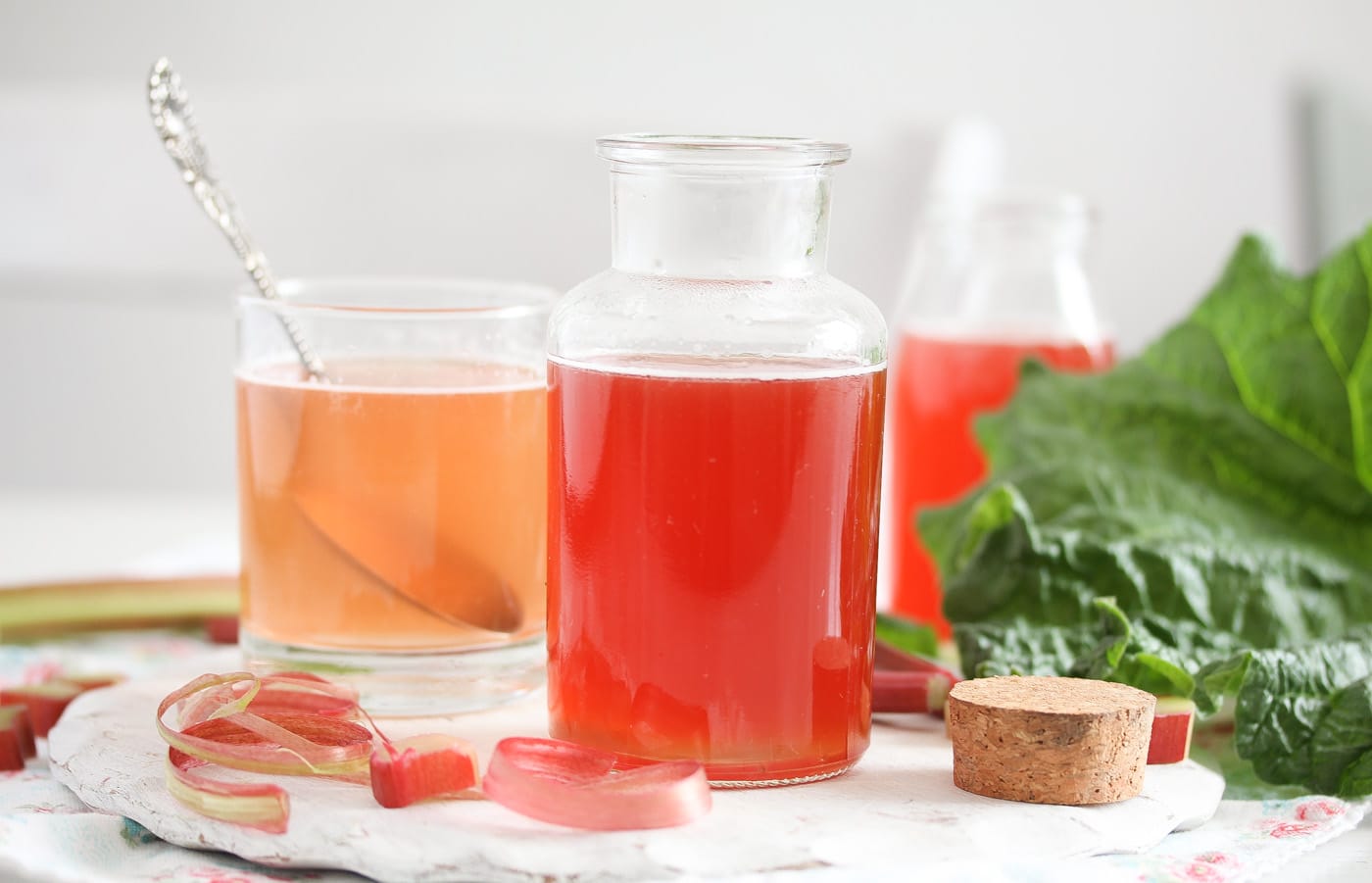 rhubarb peel syrup on the table with leaves behind