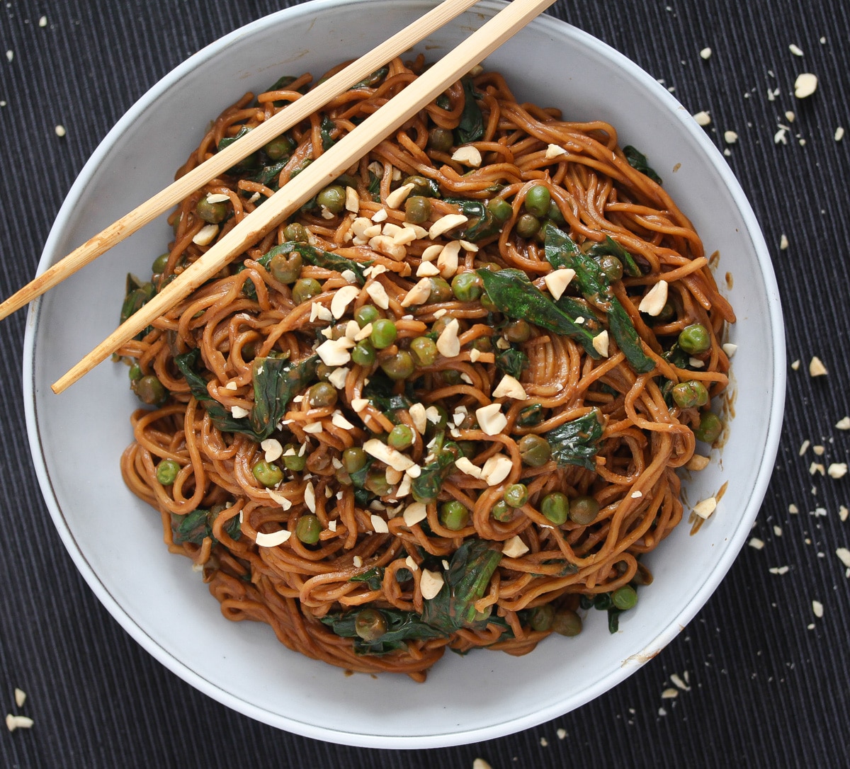 bowl of chinese noodles with brown sauce and spinach