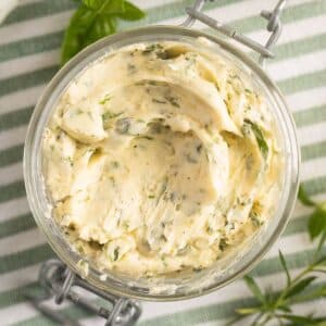 overhead view of creamy compound garlic herb butter in a jar.