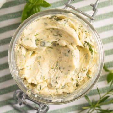 overhead view of creamy compound garlic herb butter in a jar.