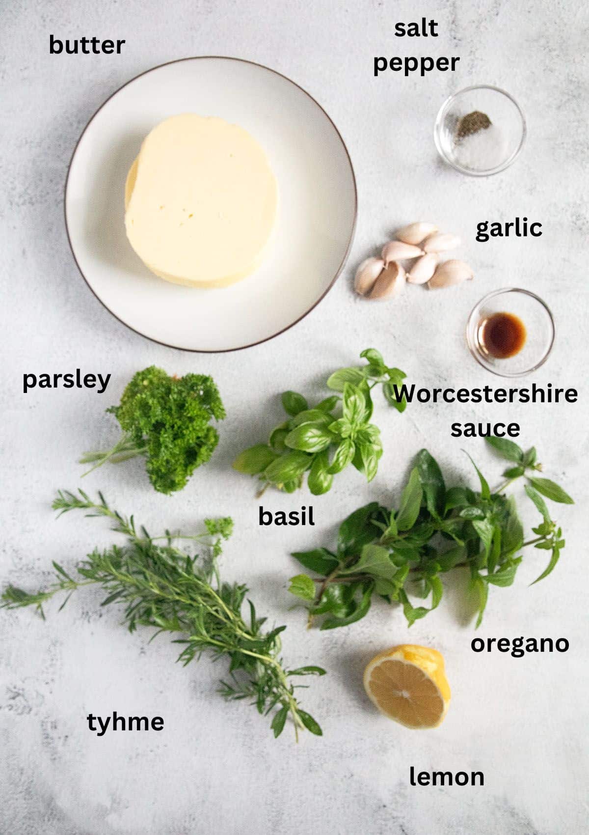 butter, condiments, fresh parsley, oreagano, tyhme and basil, lemon half on the table.