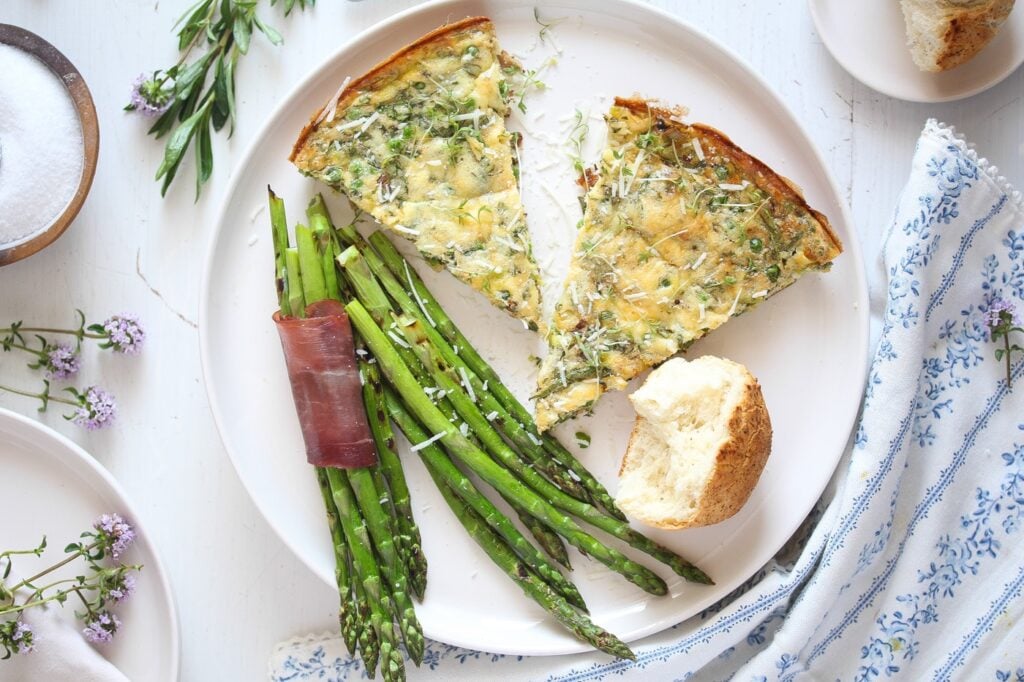 frittata wedges with dinner rolls and asparagus