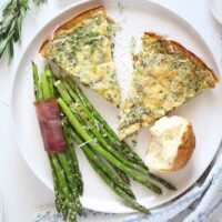 frittata wedges with dinner rolls and asparagus