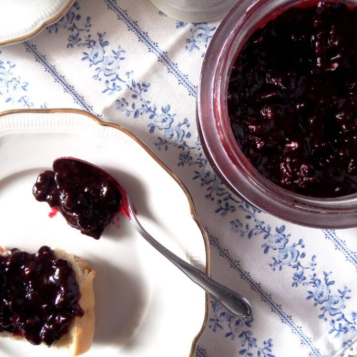black currant jam in a jar and on a slice of bread