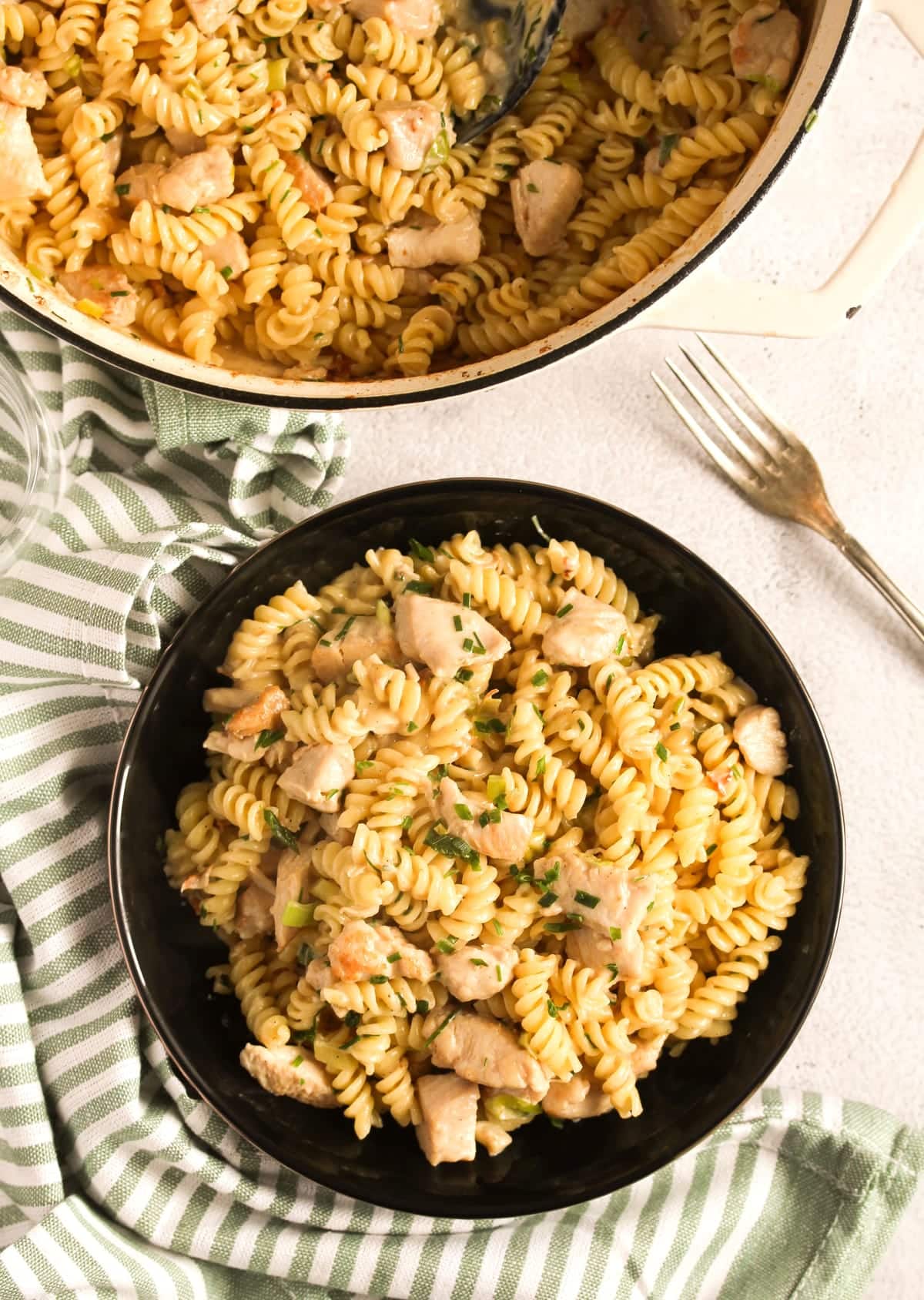 bowl and pot with chicken fusilli pasta with feta cheese.