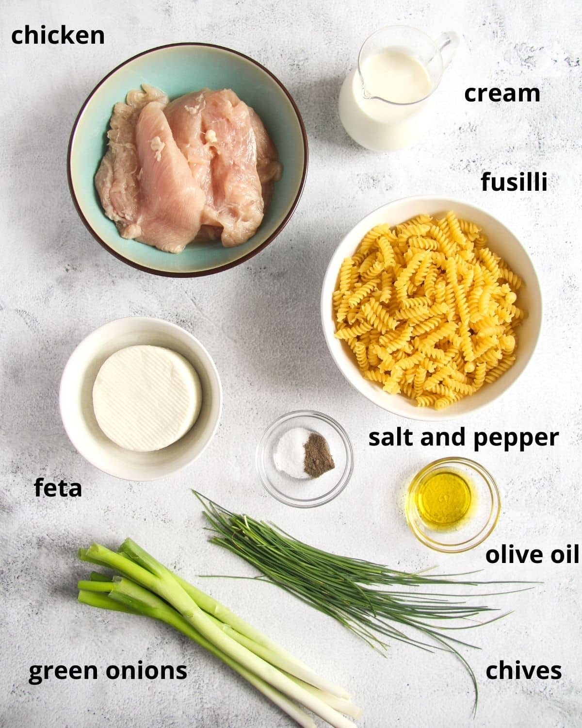 all ingredients for chicken fusilli with feta arranged on the table. 