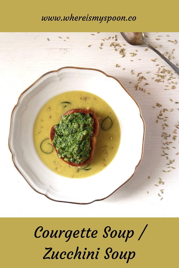 zucchini soup in a bowl with baguette slice on top