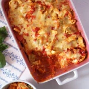 tortellini vegetable bake with cheese on top in a casserole dish.