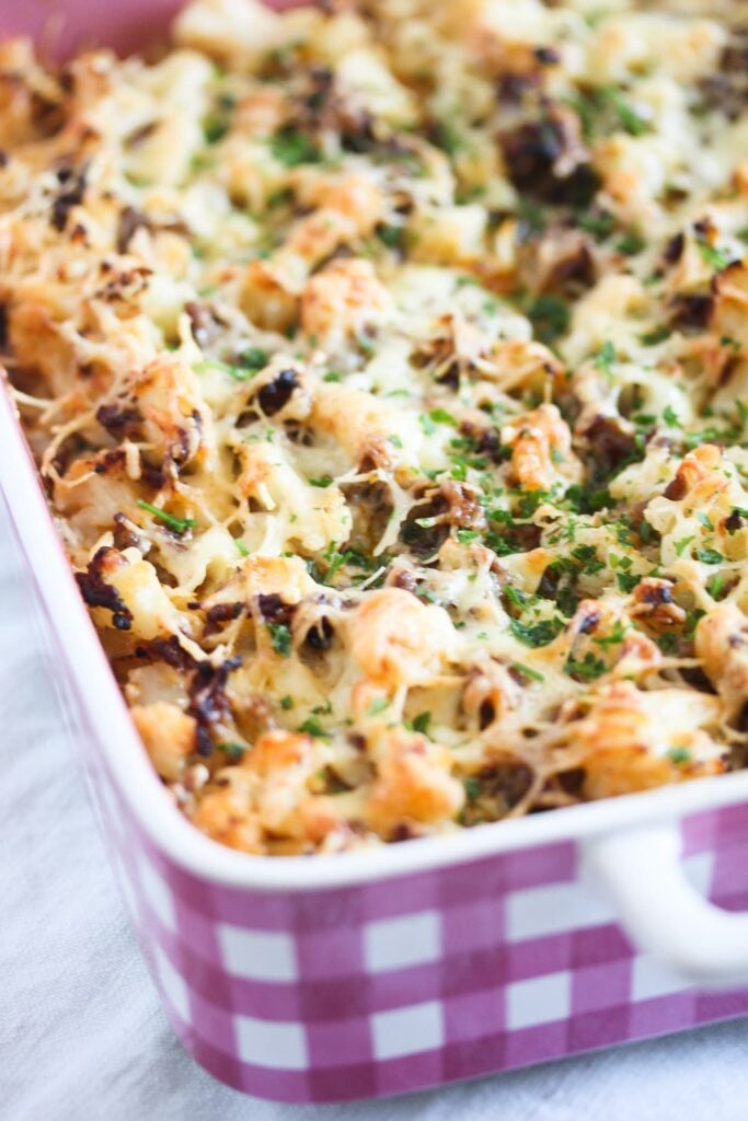 beef bake with cauliflower and cheese in a pink baking dish