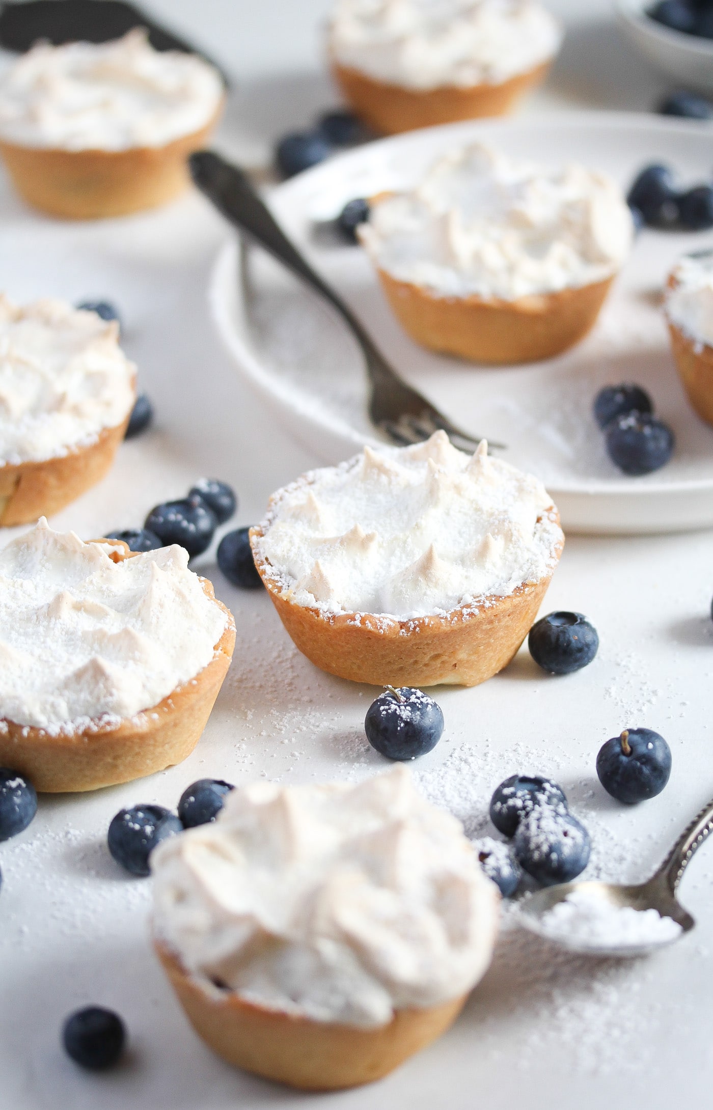 mini blueberry tarts with meringue topping on the table