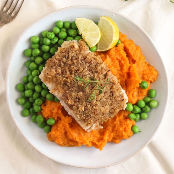 salmon and sweet potato mash served with peas on a plate.