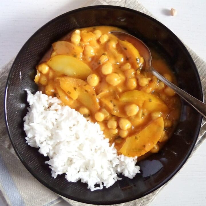 black bowl with apple curry and rice.