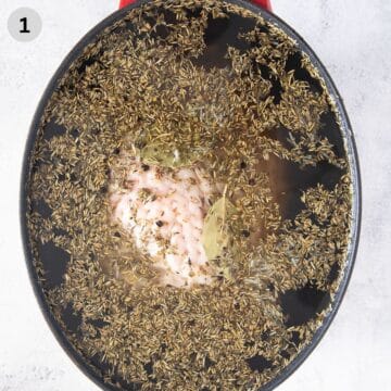 turkey breast in brining liquid with herbs in a large pot.