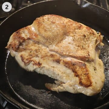 one large turkey breast searing in a cast iron skillet.
