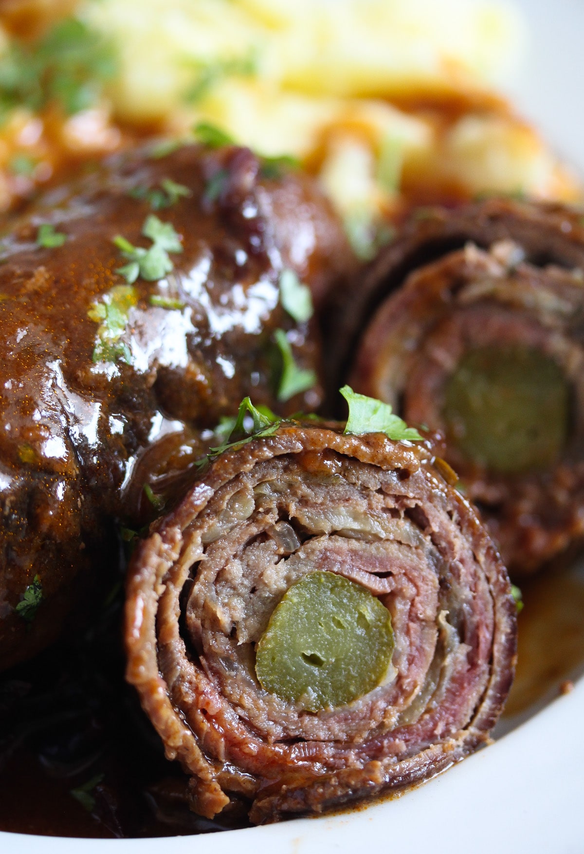close up of a sliced beef roulade with gherkin inside