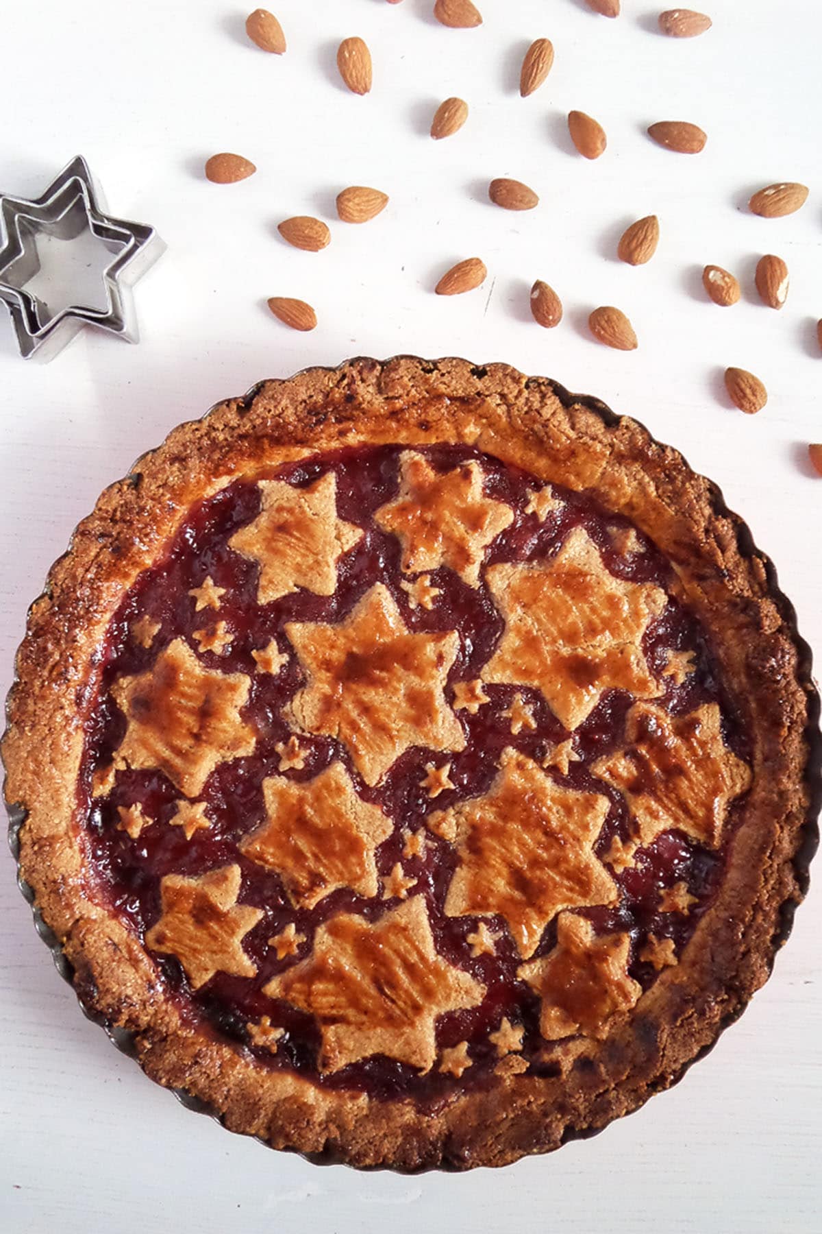 austrian linzer torte, lots of whole almonds and a star cookie cutter on the table.