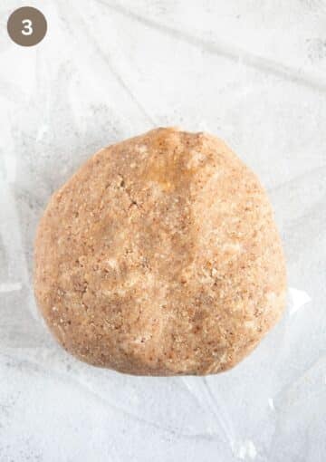 a ball of shortcrust pastry on a piece of plastic wrap.