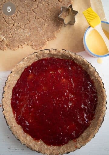 filling shortcrust in a pie form with redcurrant jam.