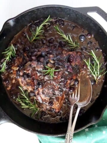 turkey breast with blueberry sauce in a cast iron skillet.