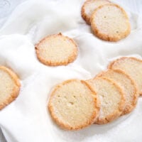 round cookies coated with sugar on a white fabric.