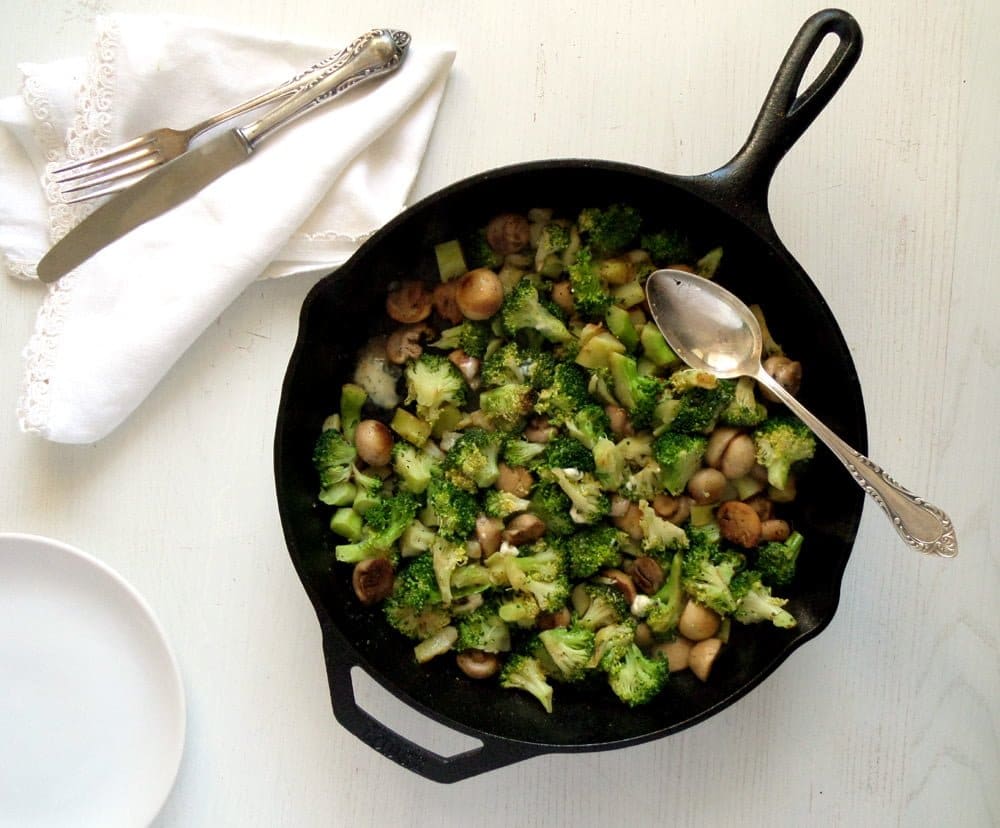 overhead view of a skillet with vegetables and vegetarian blue cheese.