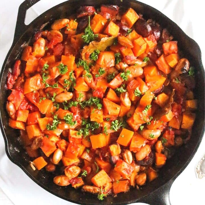 close up butternut squash and sausage casserole in a cast-iron skillet.