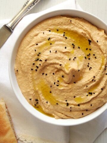 low-calorie hummus in a white bowl with flat bread