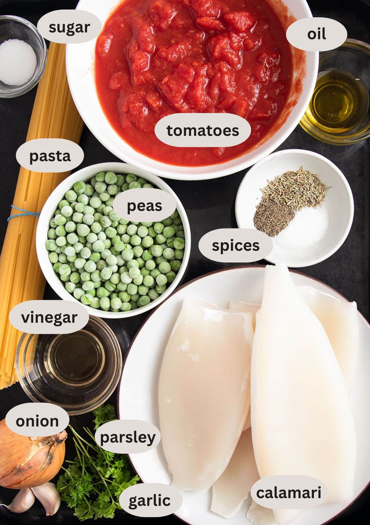 labeled ingredients for making pasta with calamari, tomatoes, and peas.