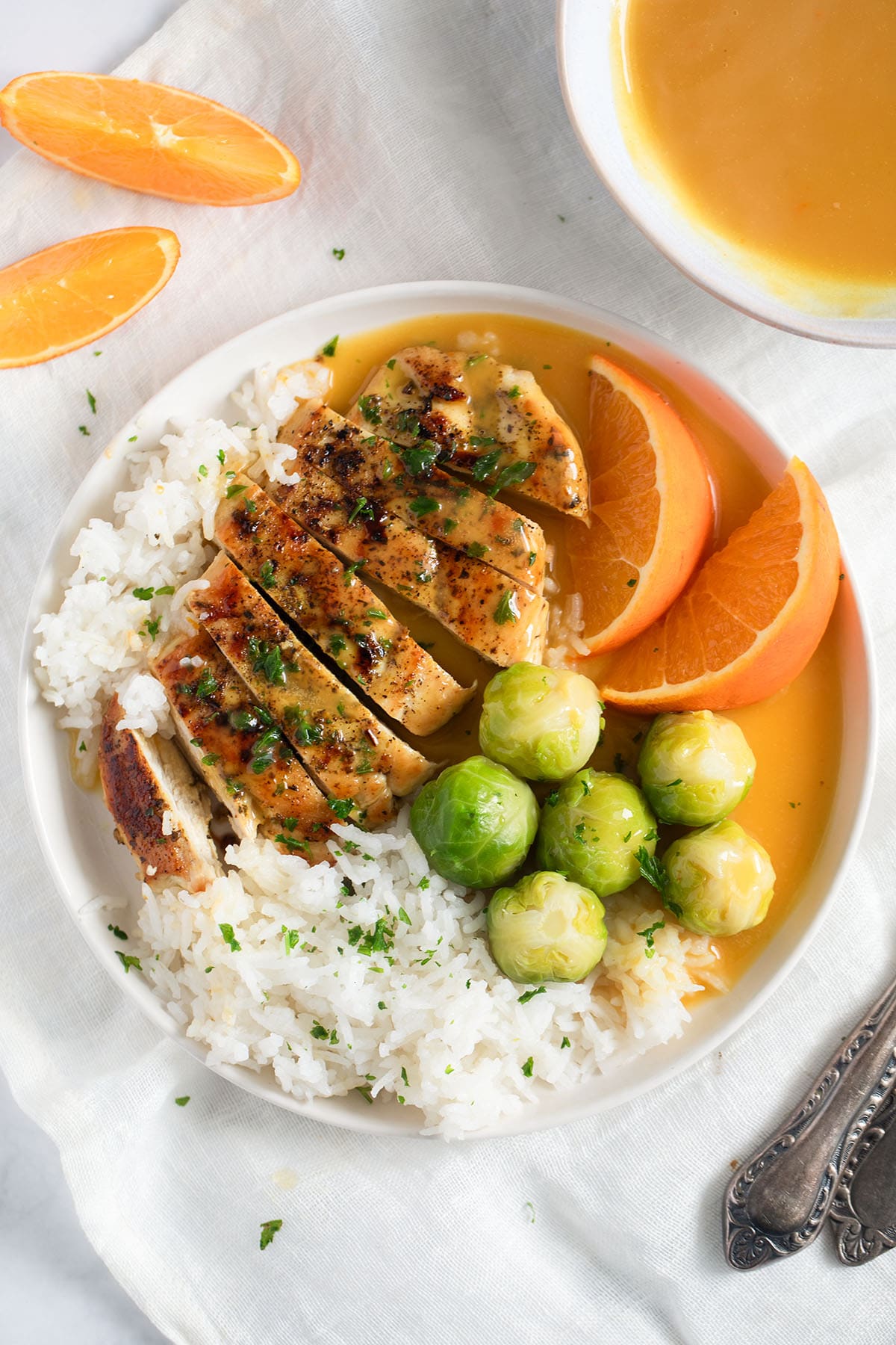 a plate with orange chicken served with rice and veggies.