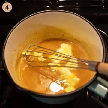 whisking butter cubes into orange sauce.