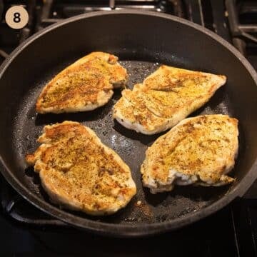 pan-frying four chicken breasts in a pan.