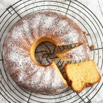 overhead view of orange bundt cake sliced on a wire rack.