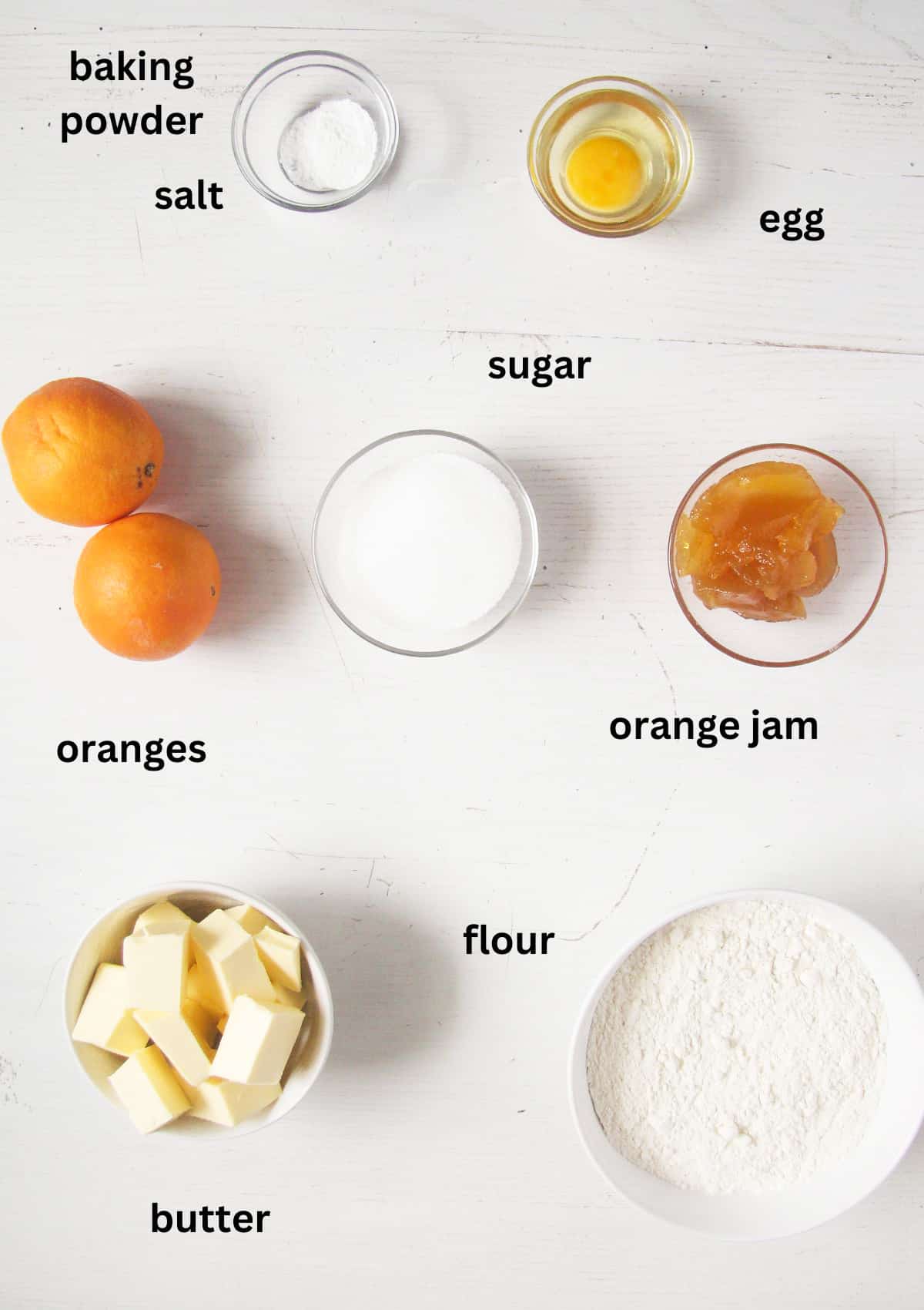 listed ingredients for making cookies with orange jam on the table.