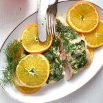 salmon with white wine sauce served with orange slices